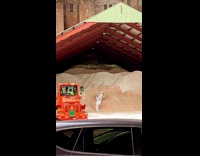 Two people wearing white spacesuits climb dirt 