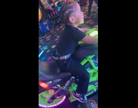 Kid does handstand while on arcade motorcycle