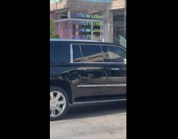 Woman poses in front of pastel store 
