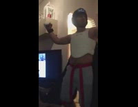 Guy wearing boxing gloves and chest protector and fights friend in the corner