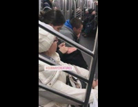 Woman knits pink beanie on subway train 