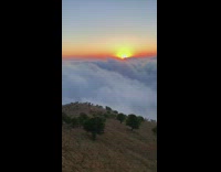 Guy red sneakers sits above clouds mountain 