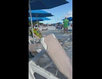 Woman in bikini and cap lie down selfie at the beach