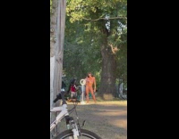 Woman in pink bikini tiktok dance at the park