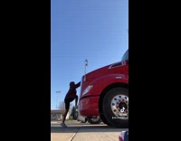 Guy has trouble lifting red truck hood