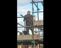 Grey shirt guy plays electric guitar scaffolding 