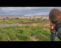 Red helmet guy rides snowmobile through puddle 