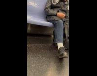 Man wears silver headdress sleeps in subway