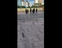 Eight people walk in sync black outfits 