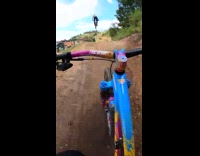 2 bikers ride in air over hill 