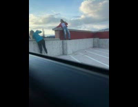 Collab IITW - Woman in pink jean jacket bends on the parking lot rooftop