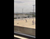 Man red hat dances rooftop parking lot