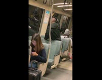 Guy shaves his head with yellow razor using window reflection on the train