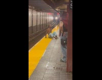 Guy cause scene sits at train platform