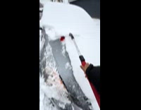 Man crying while removing snow off car