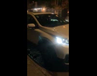 White car engine left open parked night