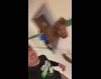 Guy running through school hallways with another guy wearing a wig 

