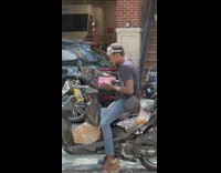 Man sit on motorcycle eat ice cream