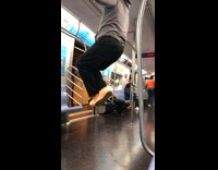 Guy blue new york hat does pull ups with ceiling handlebars on subway train