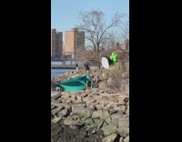 Woman in cyan dress poses at the beach rocks