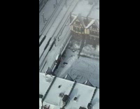 Girl watches person making snow angel outside 