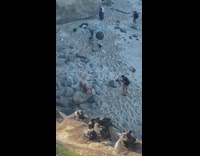 Woman in black bikini poses by the beach rocks Part 1