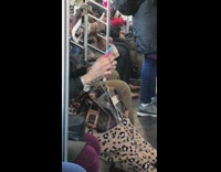 Woman very long blue pink nails untangles headphones on subway train