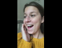 Gray cat nuzzles head and bites girls cheek