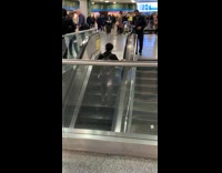 Collab Subway Creatures - Man looks at guy climbing downward escalator