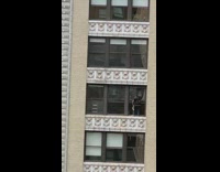 Guy stands on edge of high window 