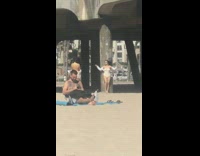 Two girls pose by bridge pier beach 