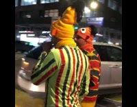 Two guys in seasame street outfits and one pics his nose