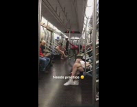 Guy red sweater dancing pole subway needs practice