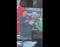 Man takes a picture of a bowl of ramen in the middle of the crosswalk