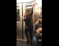 Woman holds glass of wine and pole on subway train