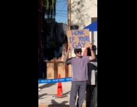 Man holds sign while woman holds banana 