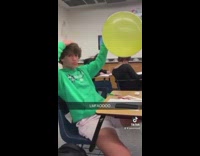 Guy rubs yellow balloon on head and then it pops