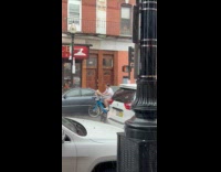 Man rides bike with flowers in rain