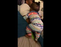 Baby climbs up to her dad and hugs him 