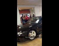 Young boy drive black car inside establishment