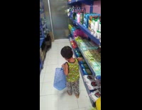 Little boy adds items to blue bag 