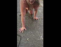 Girl crawls on ground drinks water from container 