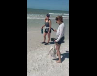 Girl photographs water bottle at beach