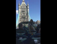 Woman stands on double deck tour bus takes picture
