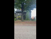 Woman drives by a house that is all black 