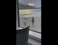 Girl poses in grey sweater on beach 