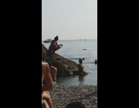 Girl green bikini on rock beach ship