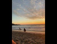 Man do acrobatic flips at beach sunset
