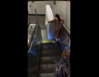 Collab Subway Creatures - Man and Woman carries mattress on escalator