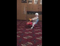 Kid on toy car falls over backwards